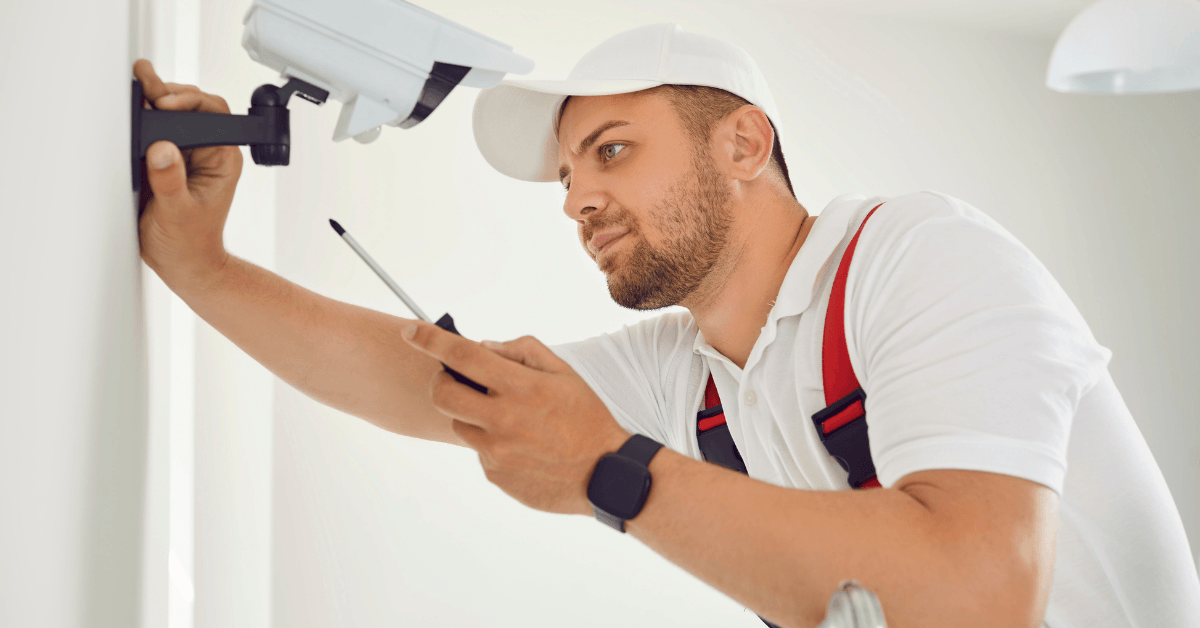Professional security technician installing an outdoor CCTV camera 