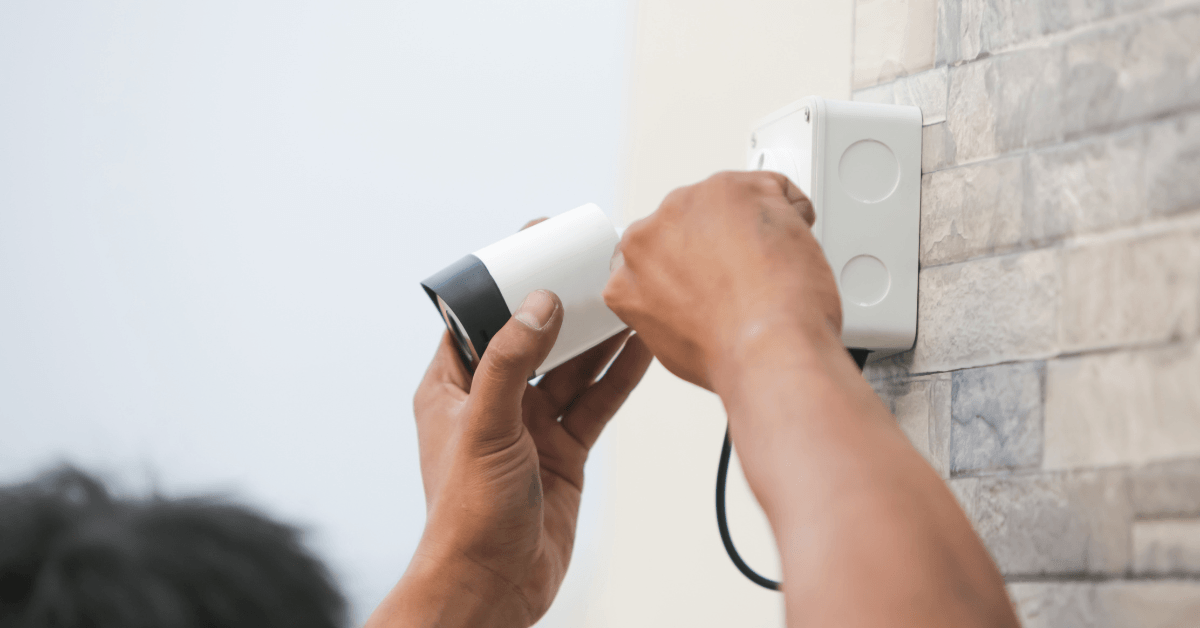 Professional security camera installer adjusting a outdoor CCTV camera 
