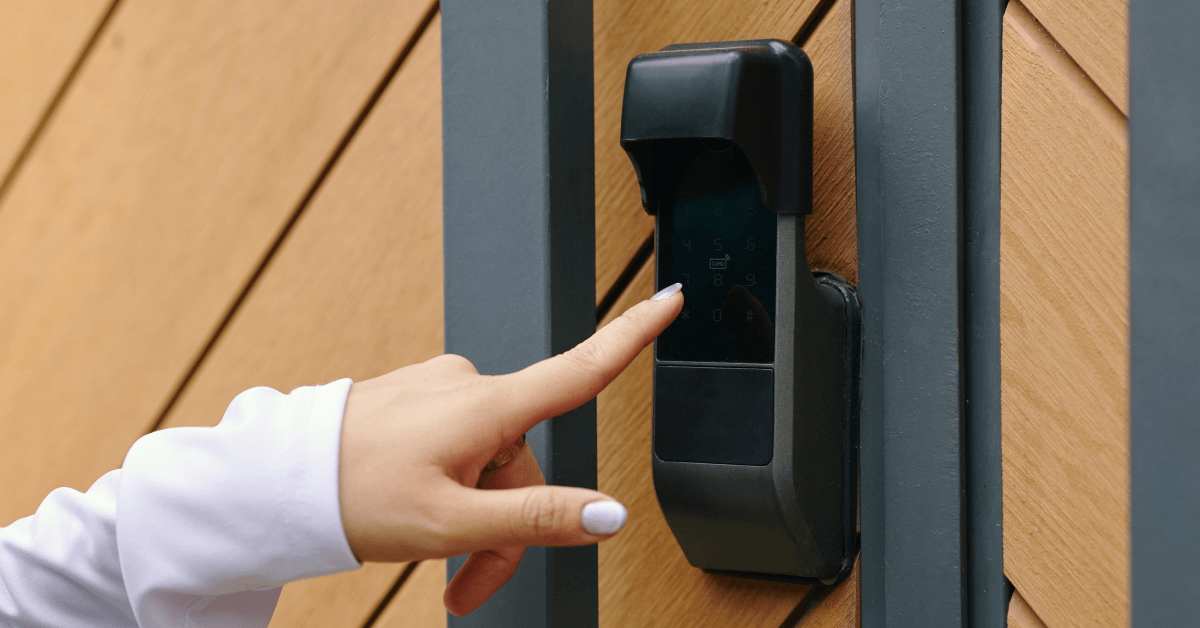 A person using a wall mounted keypad to open a automated gate 