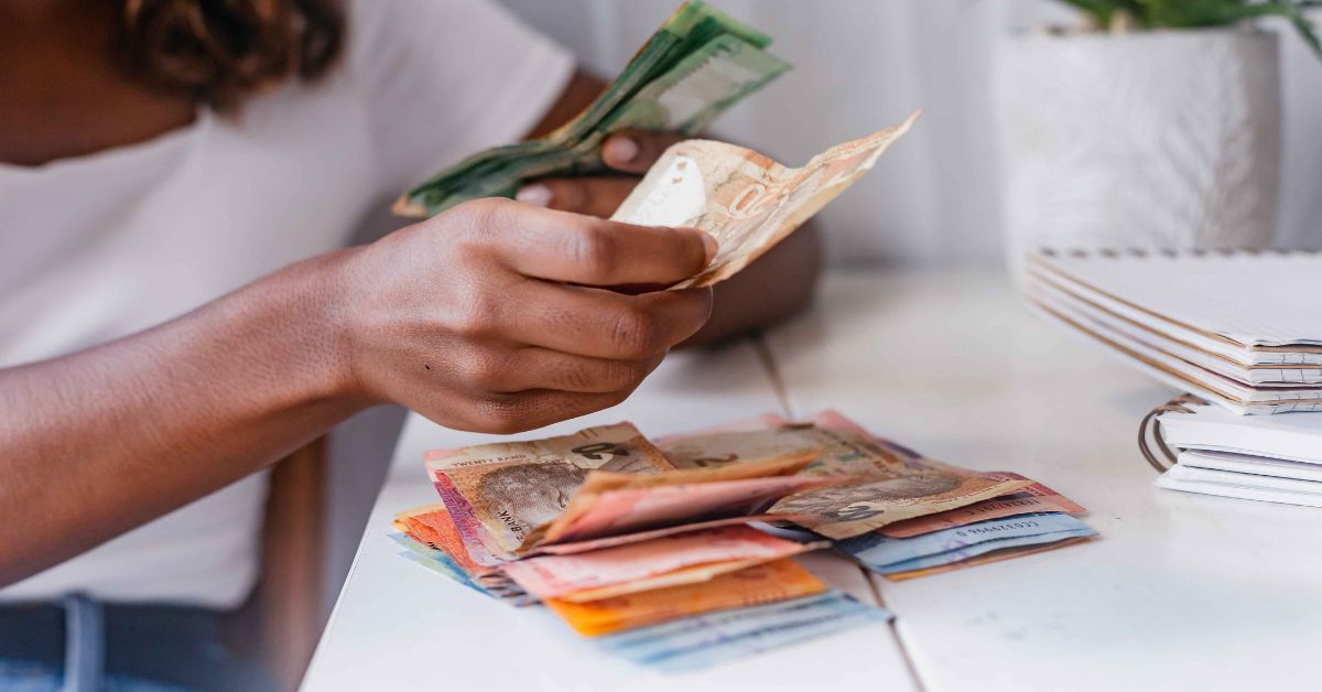 Lady counting out South African rands
