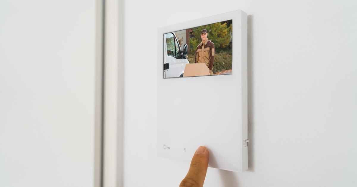 Person looking at a digital home intercom system and seeing someone on the screen