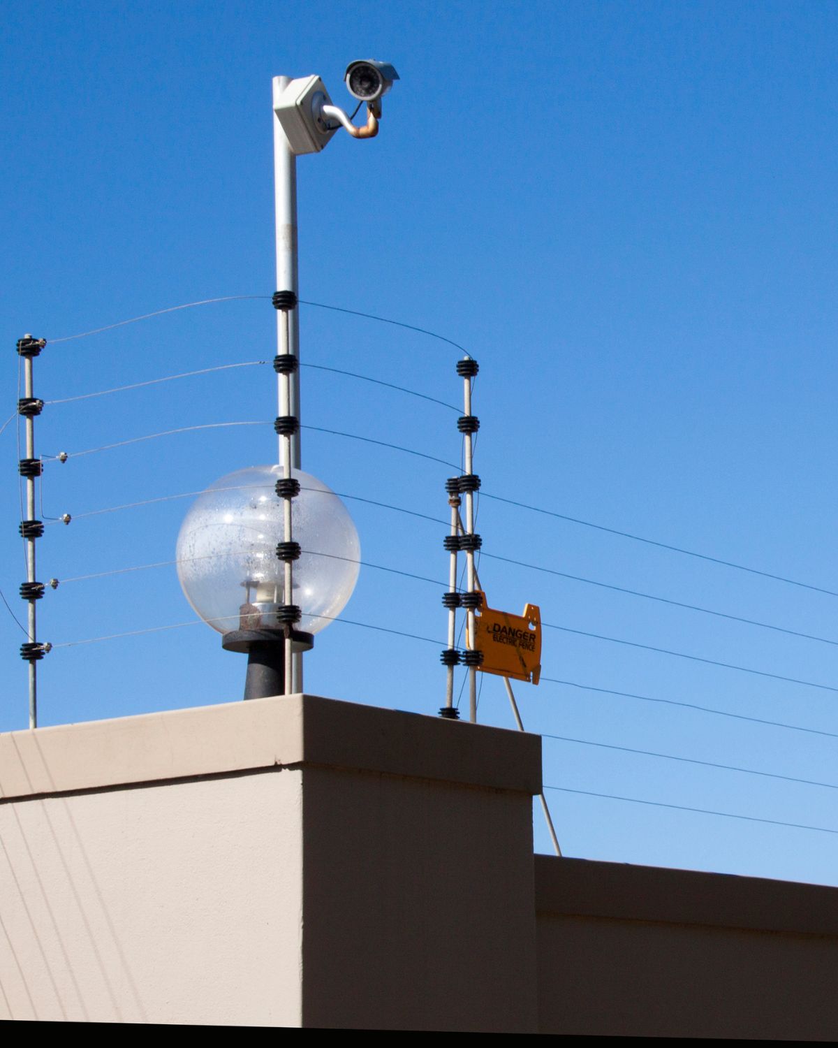 Electric Fence on a wall with a CCTV camera