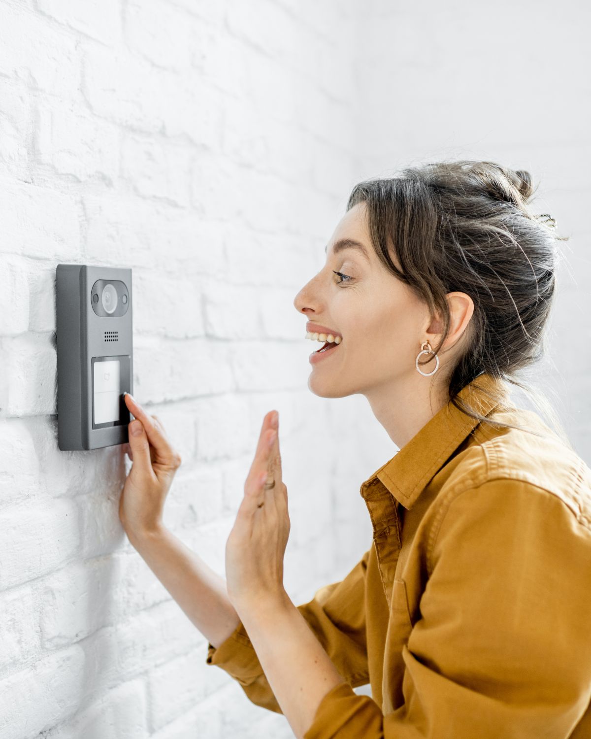 Lady with a yellow shirt talking to an intercom